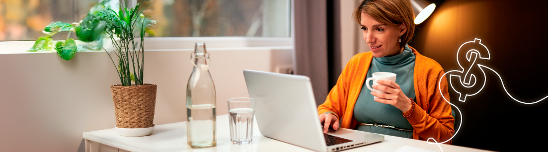 Mujer adulta tomando una taza de café mientras hace uso de un computador portatil